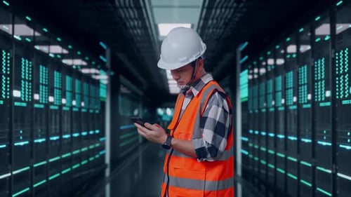 Side View Of Asian Male Engineer Using Smartphone in Data Center
