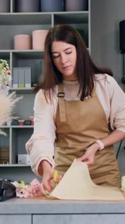 Woman Arranging Flowers in Florist Shop