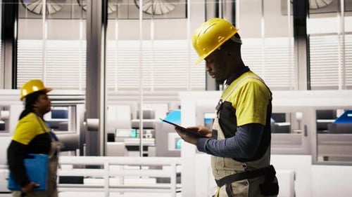 Serviceman Holding Tablet Walking in Factory Inspecting Systems