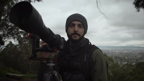 Man with Camera Gear Outdoors Overlooking City