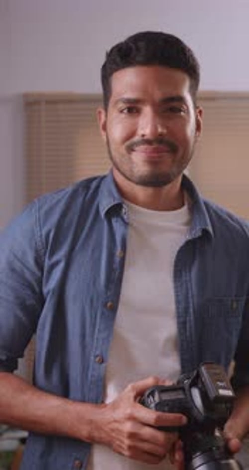 Vertical clip. Professional male photographer working in studio.