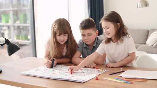 Playing a turn-based game. Positive children is indoors in the domestic room together