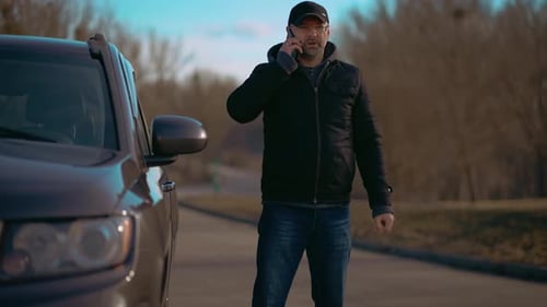 Man Talking on Phone Near Vehicle