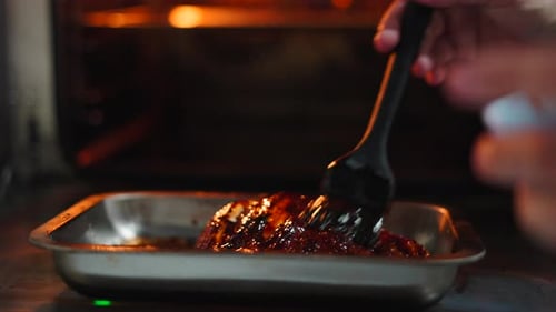 Professional Chef Preparing a Steak Brushing It with Barbecue Sauce Before Baking
