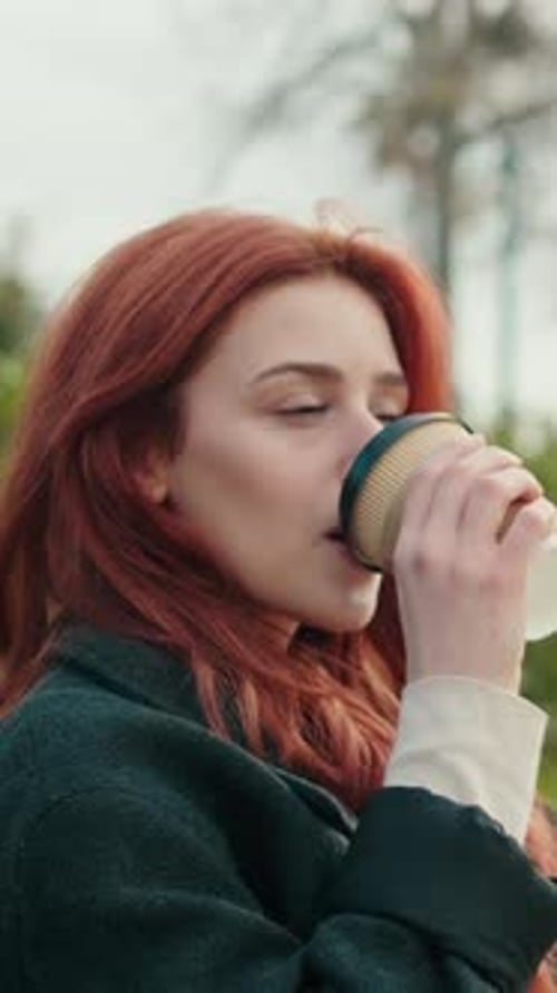 Vertical video, Woman Enjoys Coffee in the Park