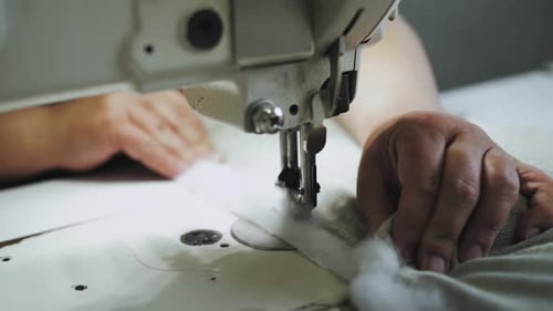 Closeup Woman's Hands Sewing Fabric on the Automatic Sewing Machine Seamstress Sews Elements for