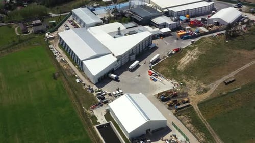 Modern factory in the countryside. Huge industrial complex among picturesque green fields. New manuf