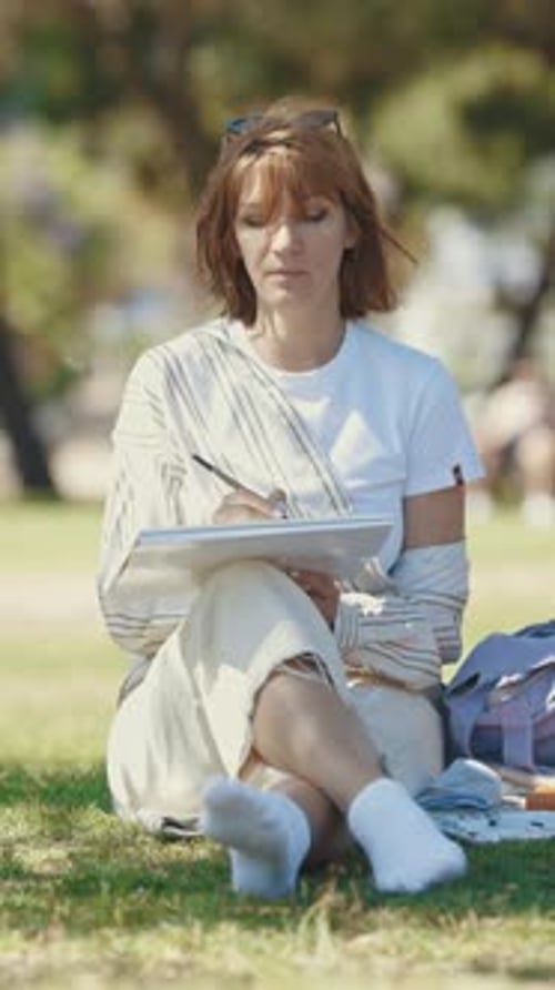 An Adult Woman Paints in the City Park