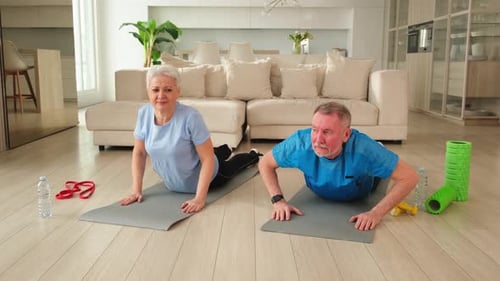 Senior Couple Stretching Together During Home Yoga