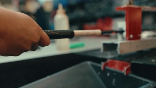 Caucasian male hands push and slide grip onto golf club shaft with water droplets dripping as vice h