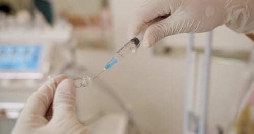 Healthcare Worker Draws Medicine into Syringe Close-up