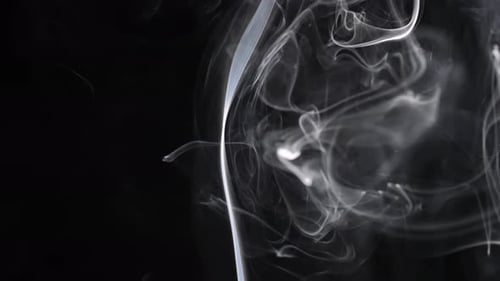 Wispy white smoke trails on a black background