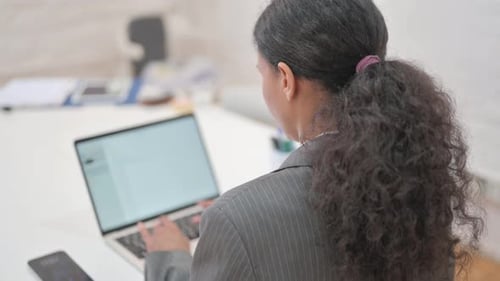 Rare View of African Business Woman Typing on Laptop