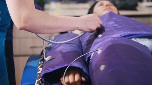 Woman receiving pressotherapy treatment at wellness clinic