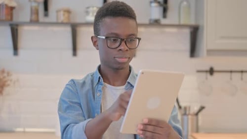 Young Adult Using Tablet Device at Home