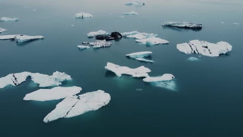 Eine Drohne fliegt über eine Gletscherlagune, deren Oberfläche eine Leinwand für Eisberge ist, auf der sie ihre eigene Karte erstellen können