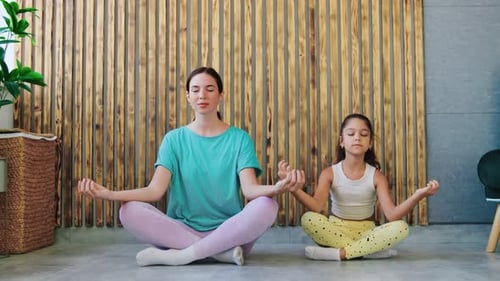 Woman and Child Meditating Together in Yoga Pose