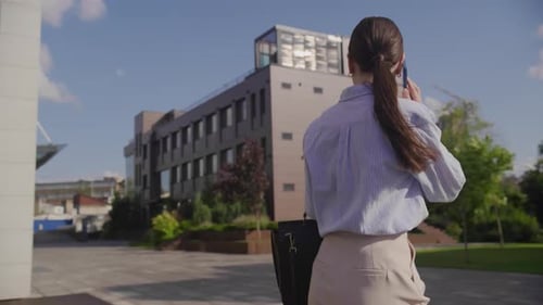 Woman Walks and Talks on Phone Outdoors
