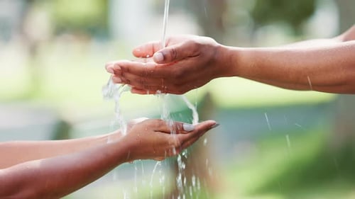 Splash, pour and water on hands outdoors for hydration or cleanliness, wash