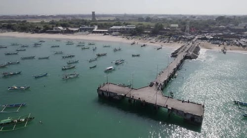 Aerial view of Indonesian traditional juking boats bobing on turquoise transparent waves near a trop