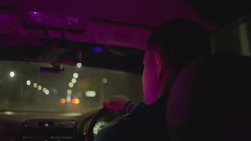 Urban Night Journey Solitary Drive Beneath Glowing City Lights at Night Male Driver Navigates