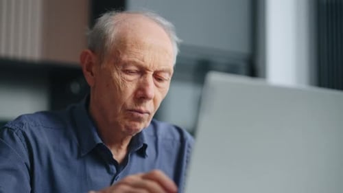 Senior Man Using Laptop at Home