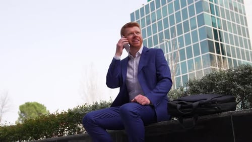 Red Haired Businessman Talking on Phone Outside