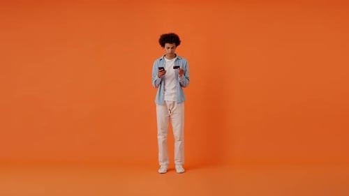 Delighted Man Using Credit Card for Online Payment in Studio