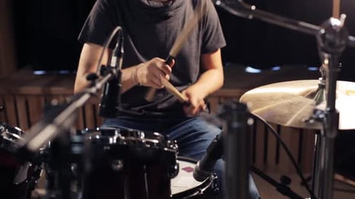 Young Adult Playing Drums in a Studio