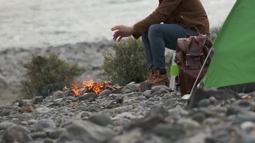 Hiker Tourist Traveler Man with Backpack Mountain Camping Fire Firewood Camp Tent Traveling Hiking