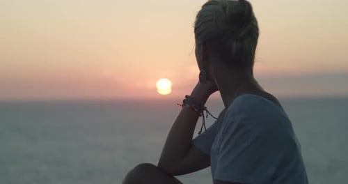 Woman enjoyin sunset sunrise. Back view. Girl relaxing on sea beach. Mediterranean sea. Cinematic me