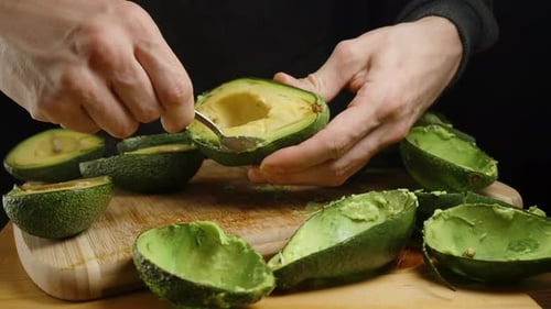 Person scooping avocado out of its skin