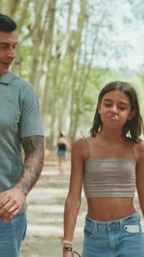 Happy family walking and talking along the path in the park