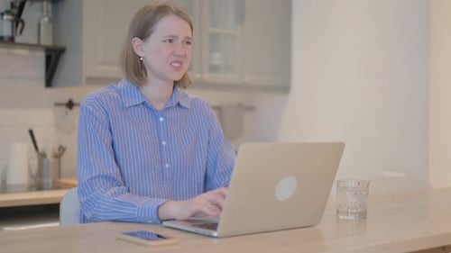 Woman Experiences Wrist Pain Working at Laptop