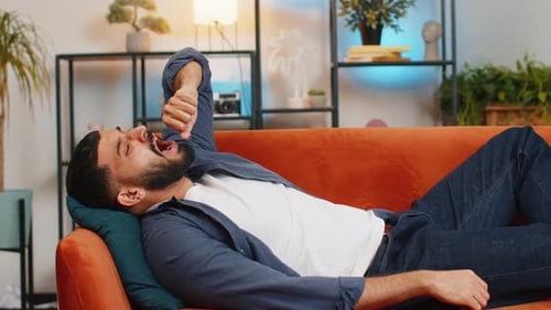 Man Yawning then Sleeping on a Comfortable Couch