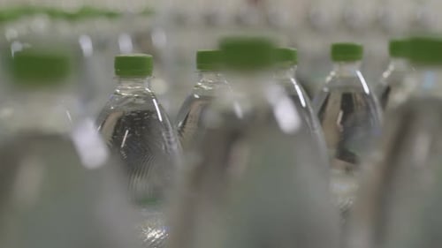 Plastic bottles filled with pure mineral water on a conveyor in a modern water filling factory with