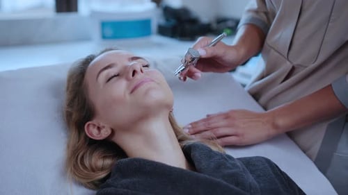 Woman receiving facial treatment at modern spa