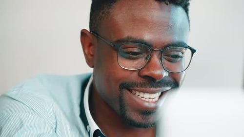 Smiling Black Man Chatting on Laptop
