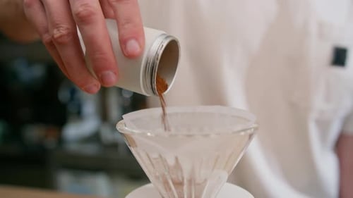 The process of making filter coffee by pouring hot water over a layer of ground coffee on the filter