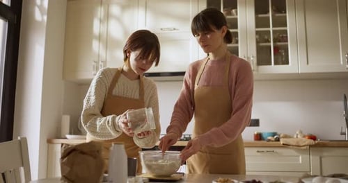 Woman and Teen Baking Together in Sunny Kitchen