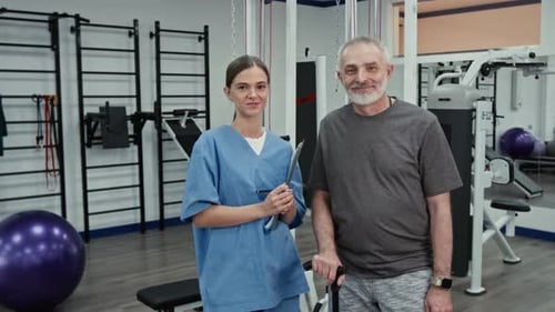 Portrait of Female Physical Therapist and Male Patient in Rehabilitation Centre