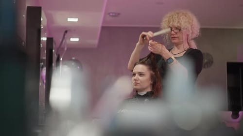 Stylist Cuts Woman's Hair in Salon