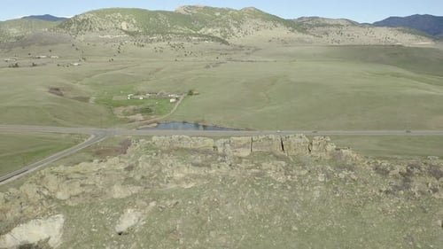 Aerial flyover rock formation and road.