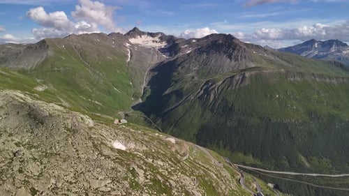 Majestic Green Alpine Mountain Peaks Under A Bright Blue Sky