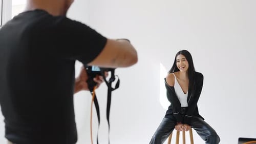 Fashion Photographer Taking Pictures of Model in Studio