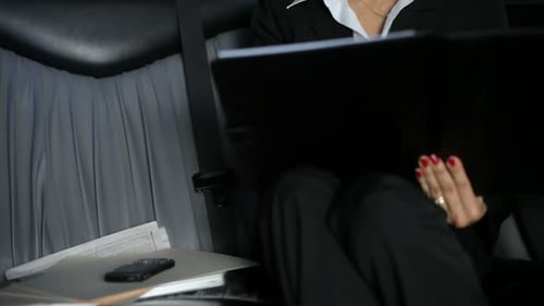 Smiling Woman Reviews Documents Inside Limousine