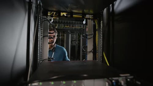 Technician Working Inside Data Center Server Cabinet