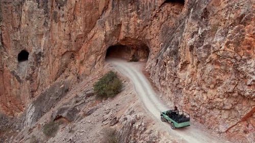 Jeep Approaching Rocky Tunnel Entrance on Cliffside Road in Kemaliye Canyon, Turkey
