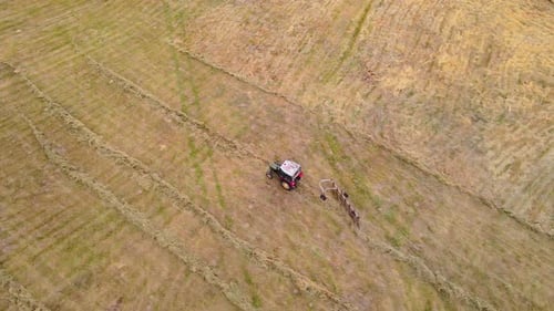 Aerial View Tractor Working at Field with Trailer for Flipping Hay Rural Countryside Meadow with