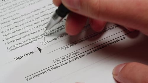 Close Up of Document Being Signed and Checked